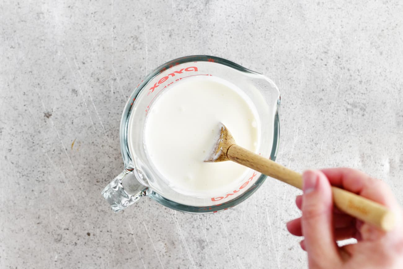stirring buttermilk in glass measuring bowl