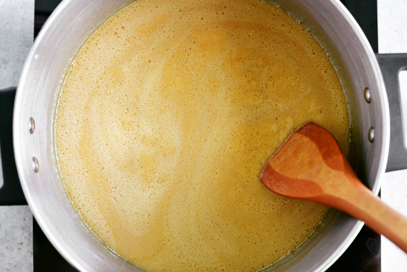 stirring caramel syrup with wooden spoon