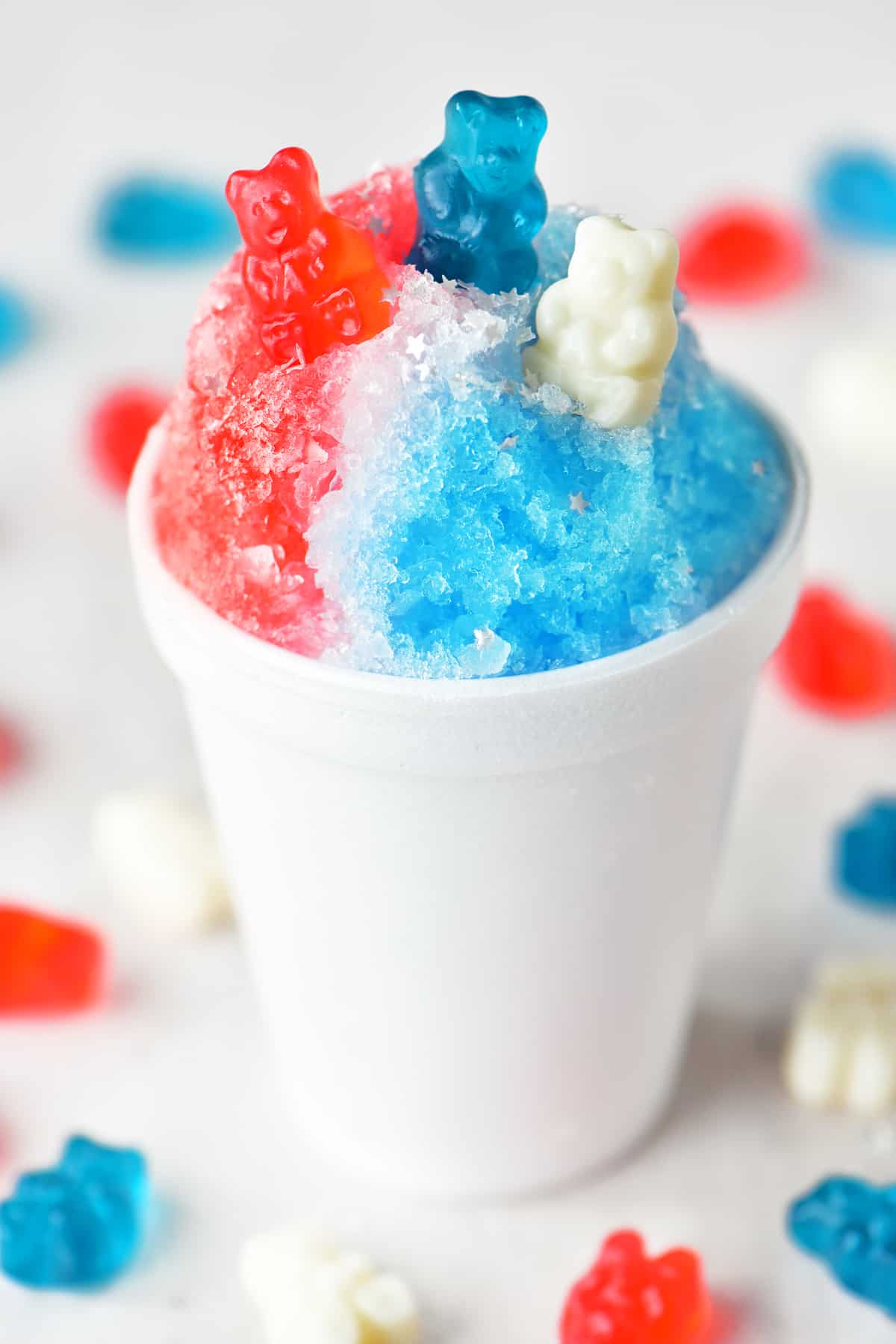 a red white and blue themed shave ice treat, with red, white and blue gummies on top