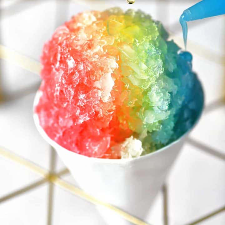 adding yellow and blue syrups to a classic snow cone