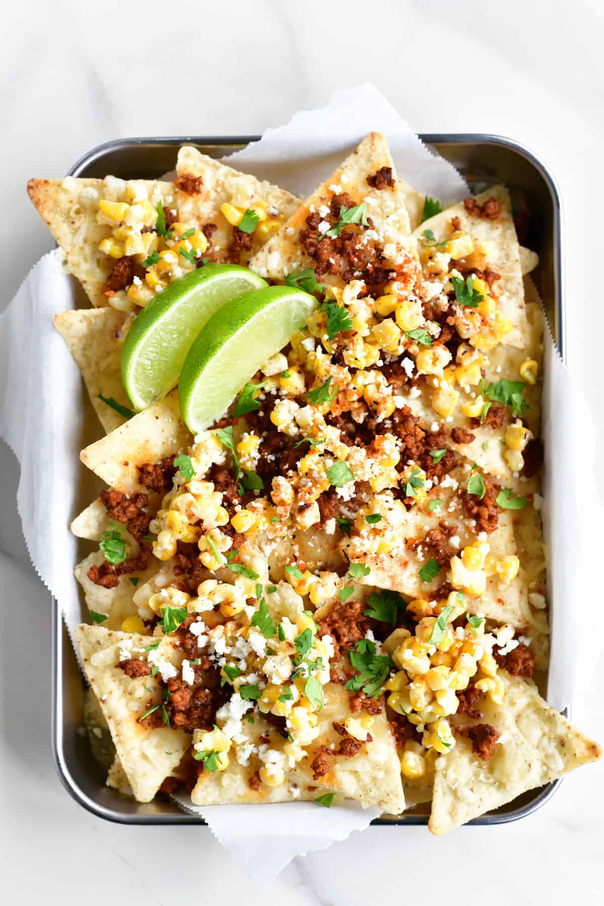 Mexican Street Corn nachos in a tray with lime garnish