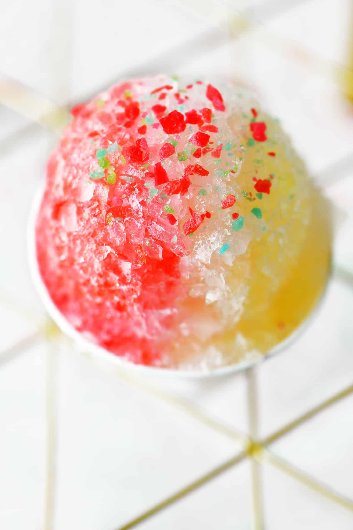 a red, white and yellow snow cone with Pop-Rocks candy on top