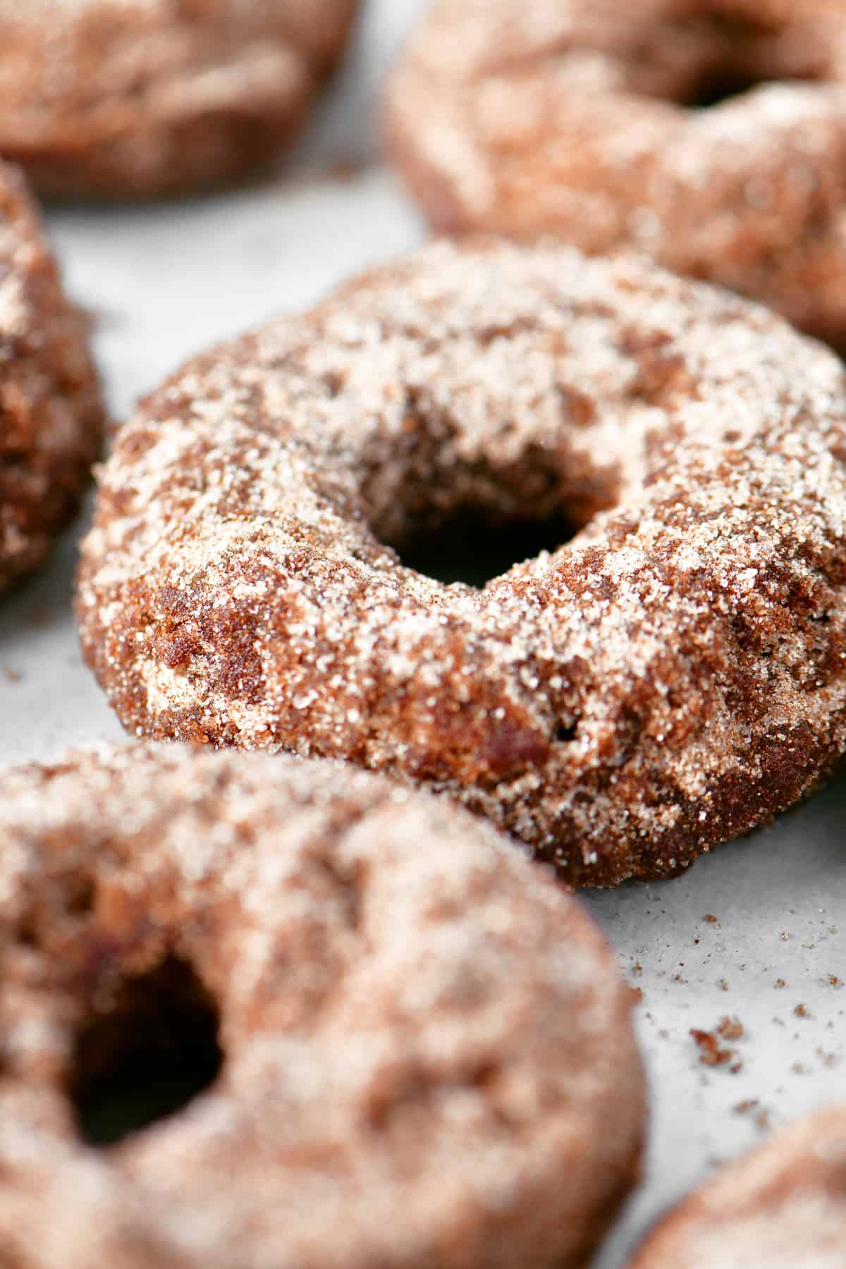 a close up photo of apple cider donuts on a baking sheet