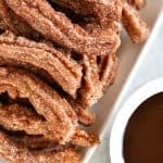 churros on a tray with a bowl of chocolate sauce