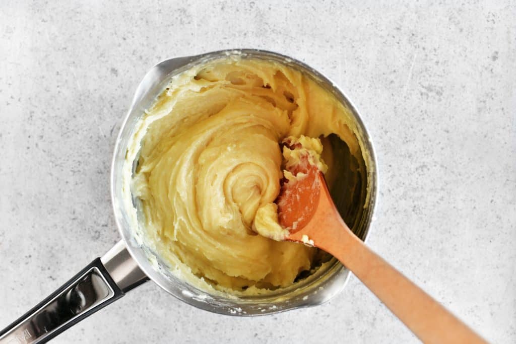 stirring the cream puffs dough in a saucepan