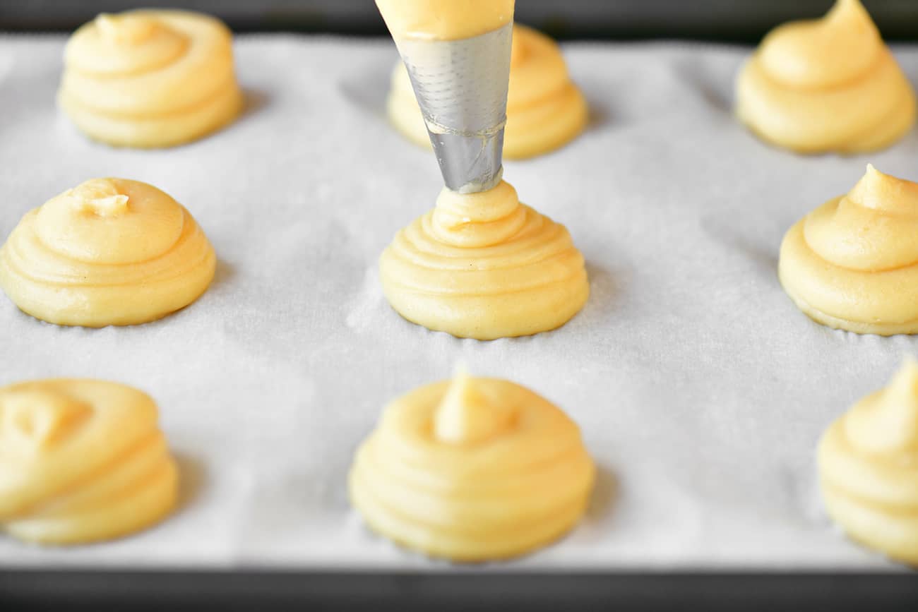 squeezing out the cream puff dough with a pastry bag