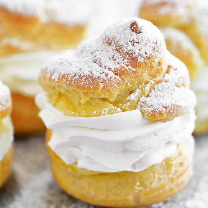 cream puff close up with whipped cream and powdered sugar