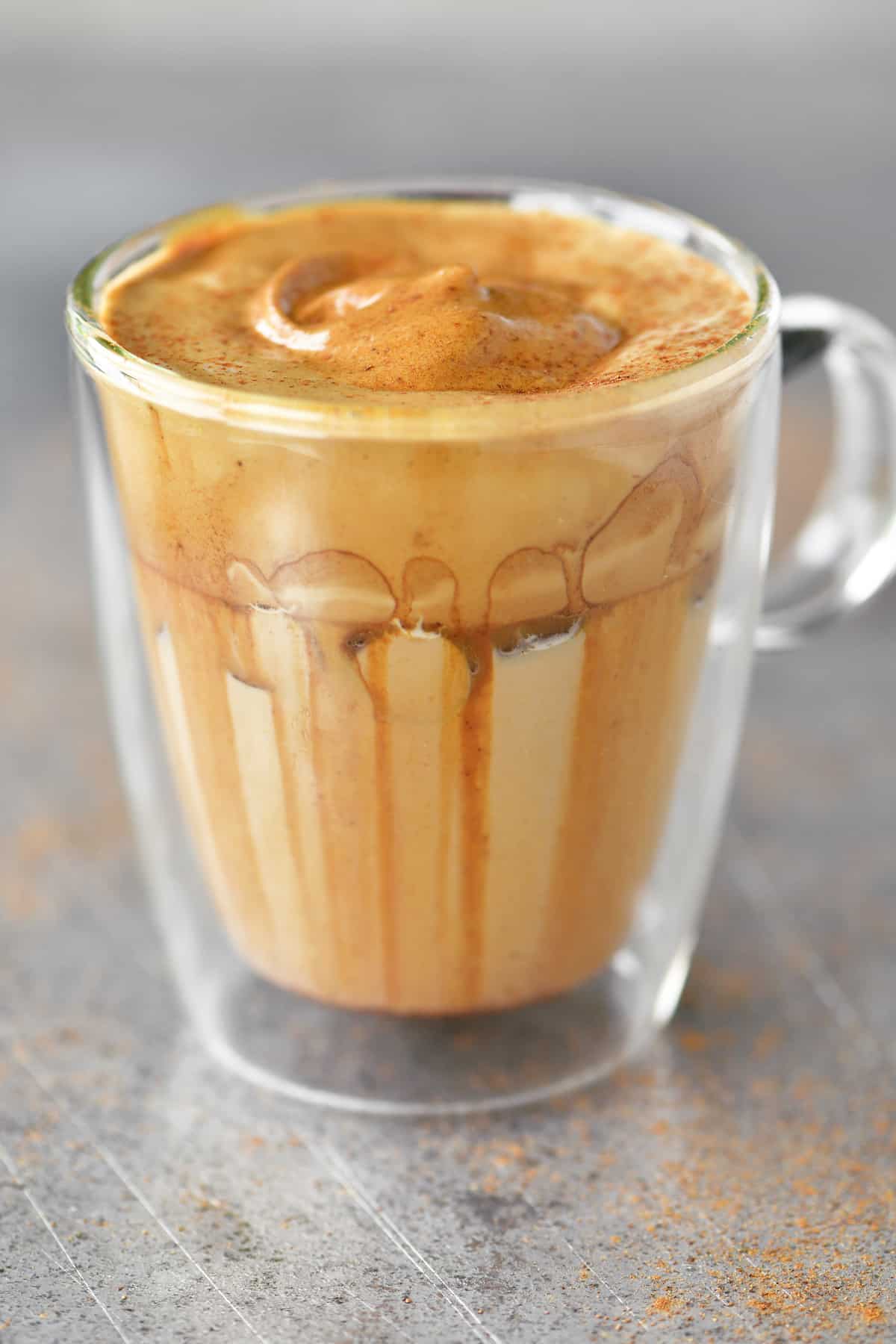 side view of a glass cup with whipped coffee in it