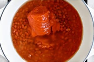 adding tomato soup to the chili beans