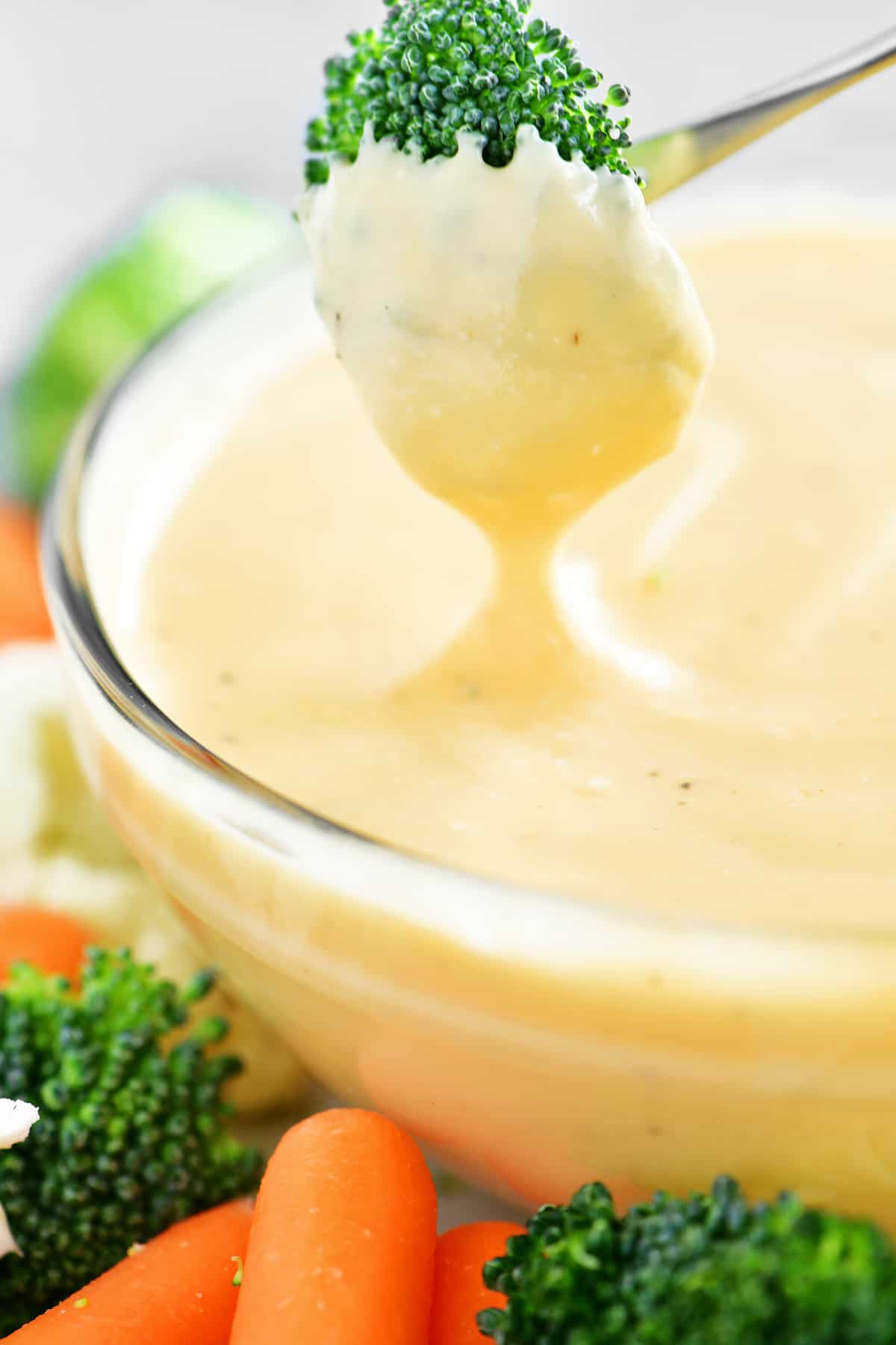 dipping broccoli in cheese sauce