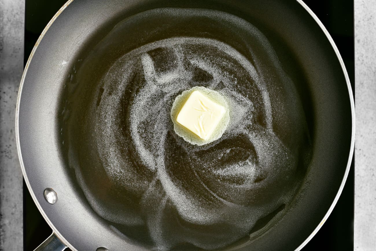 melting a pat of butter in a frying pan