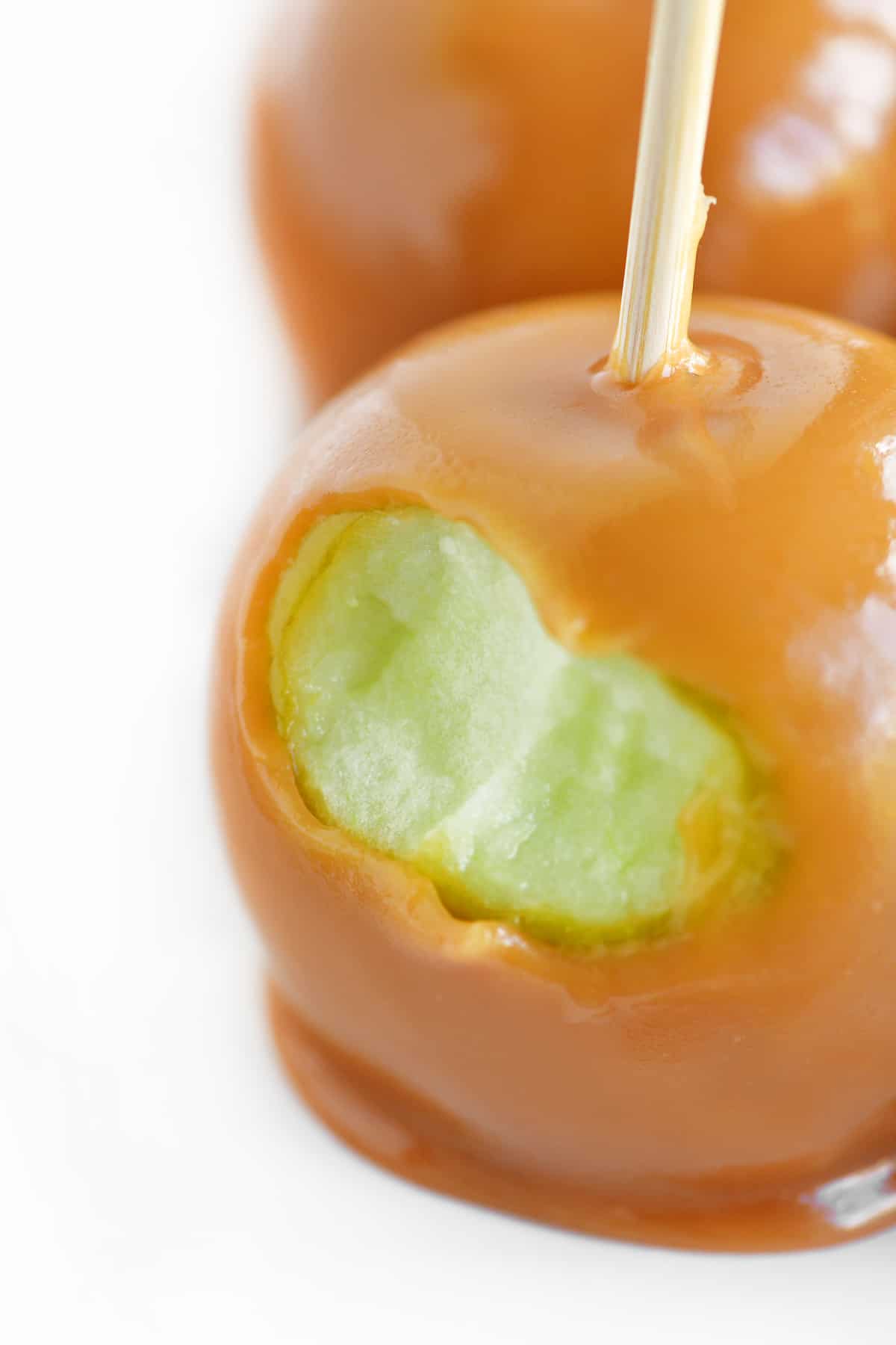 a photo of a caramel apple with a bite out of it