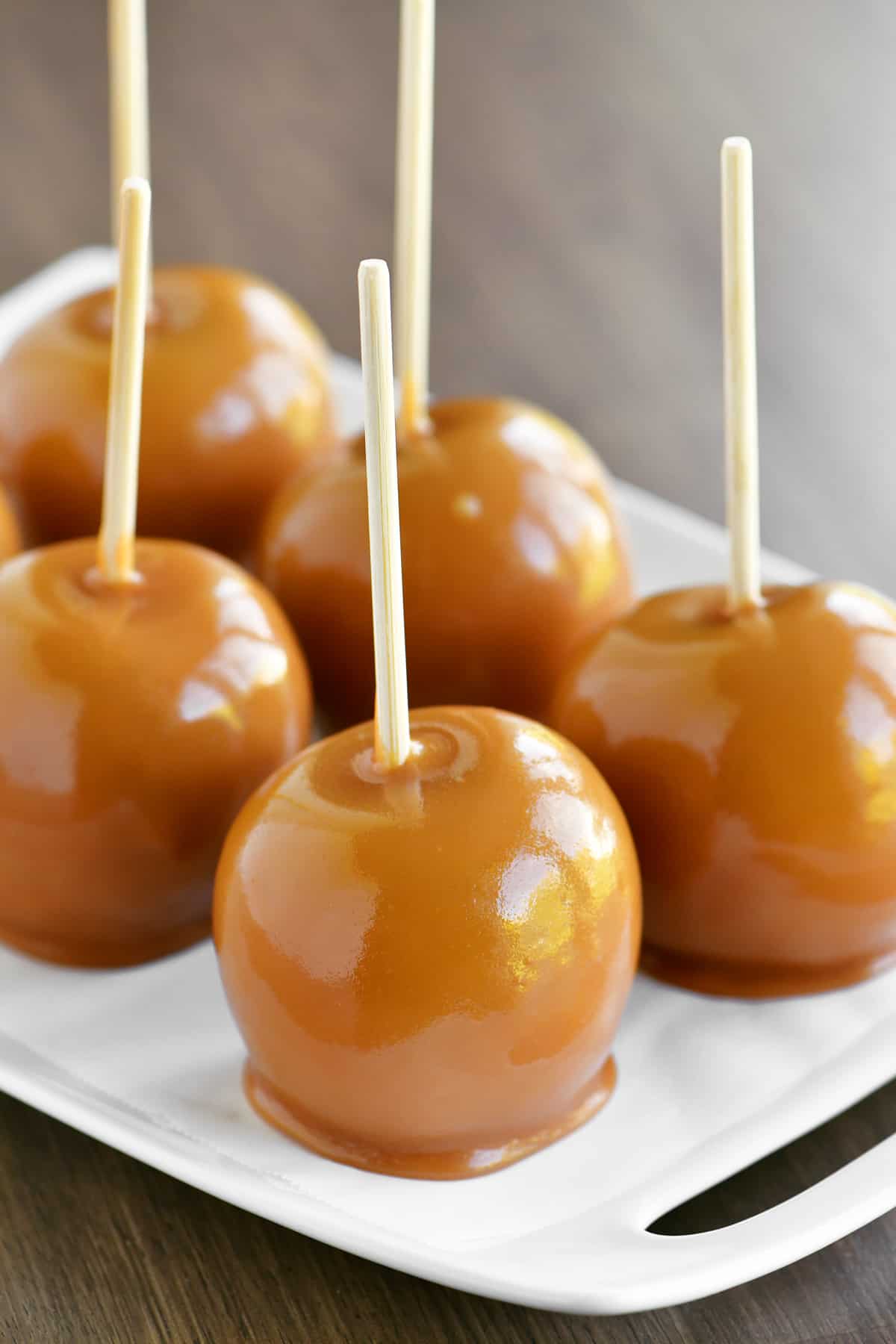 a close-up photo of caramel apples on a tray