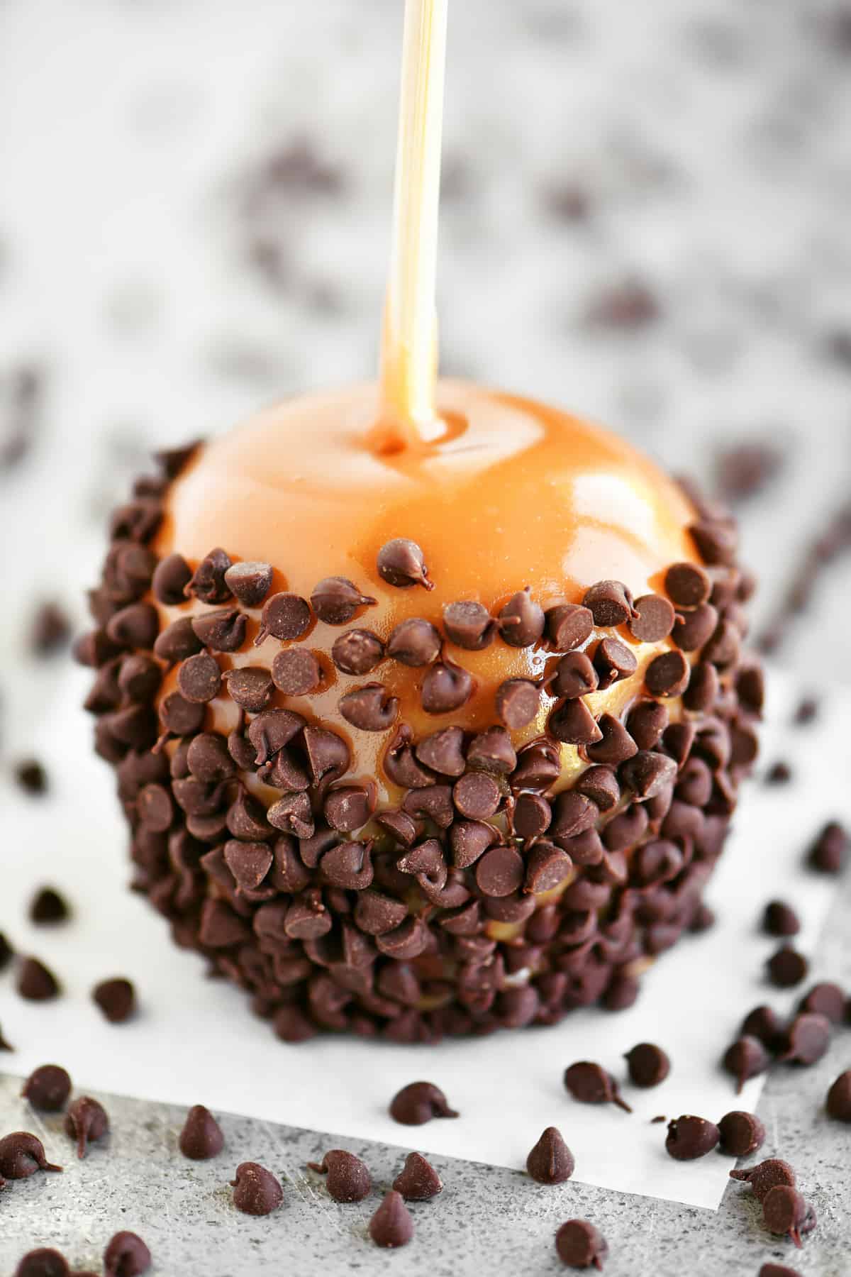 a photo of a caramel apple with mini chocolate chips on it