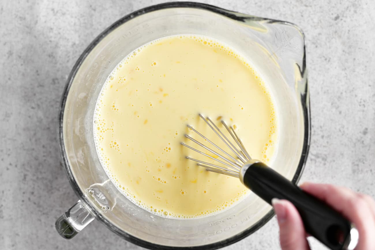 mixing the eggs and milk with a whisk
