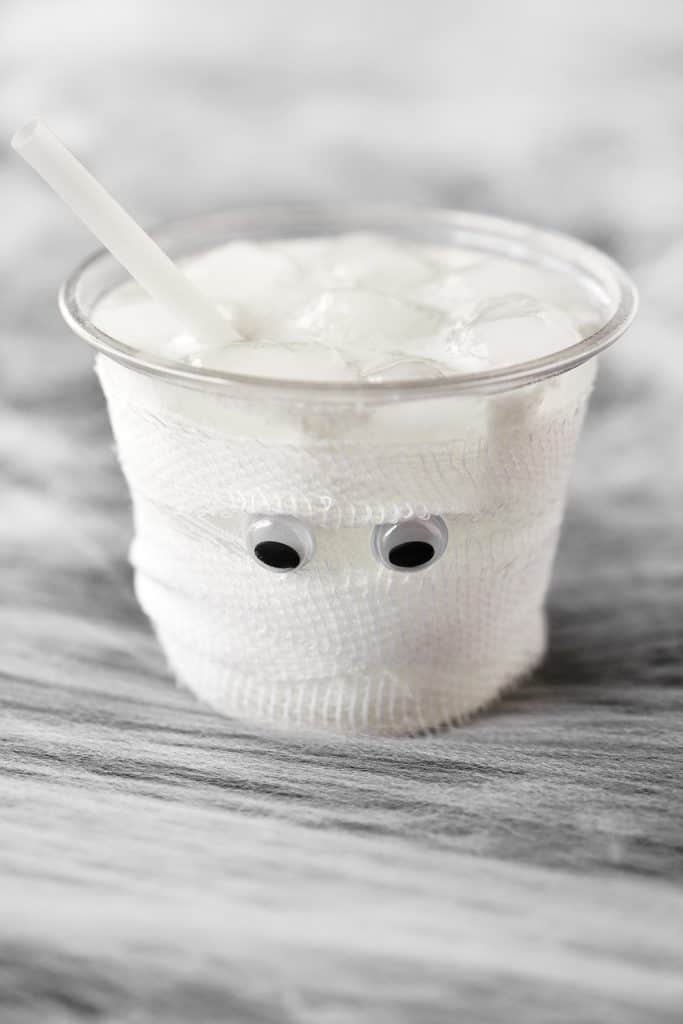 Mummy drink for Halloween with gauze and googly eyes.