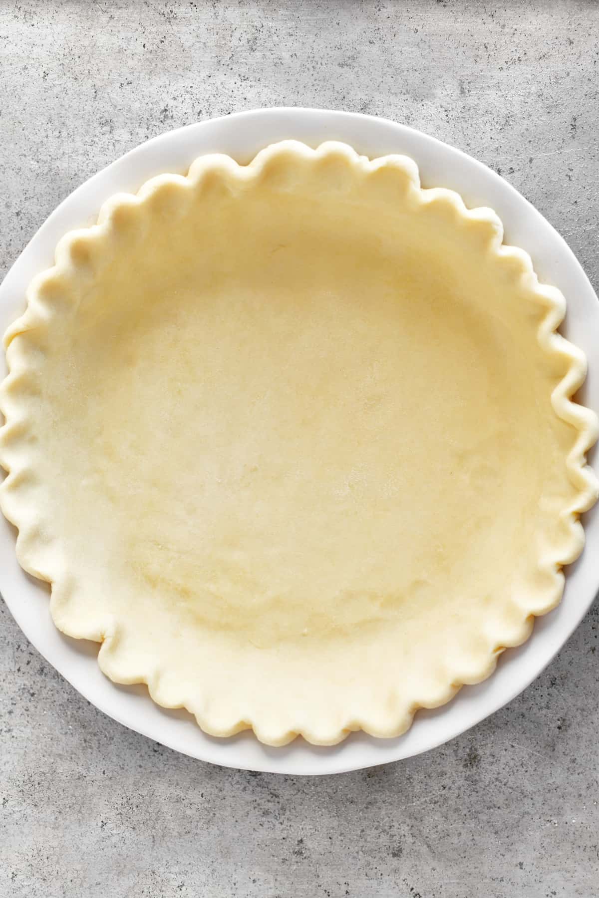 unbaked pie crust in white ceramic pie plate