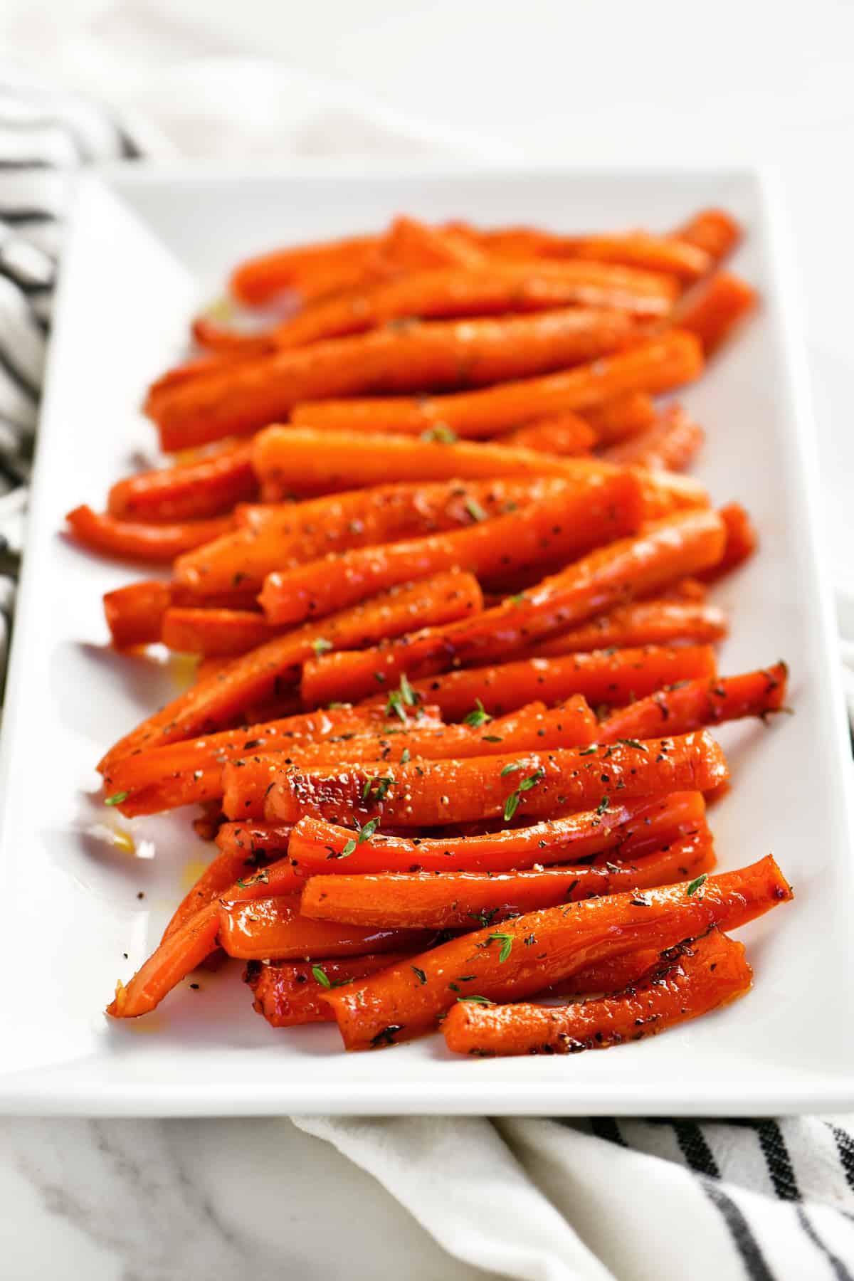 honey glazed carrots lined up on a serving tray