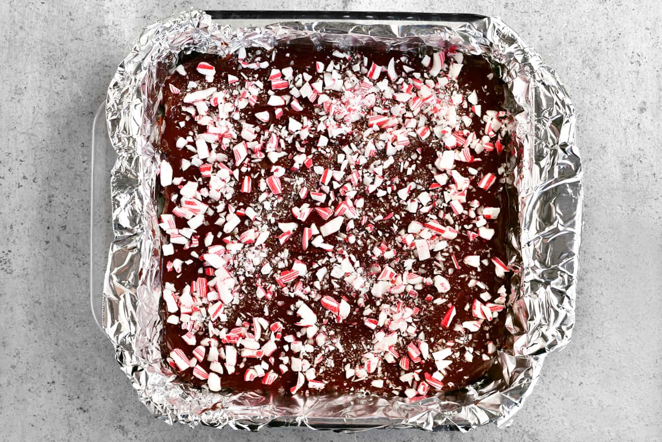 adding the candy cane chips to the top of the peppermint patties bars in the baking dish