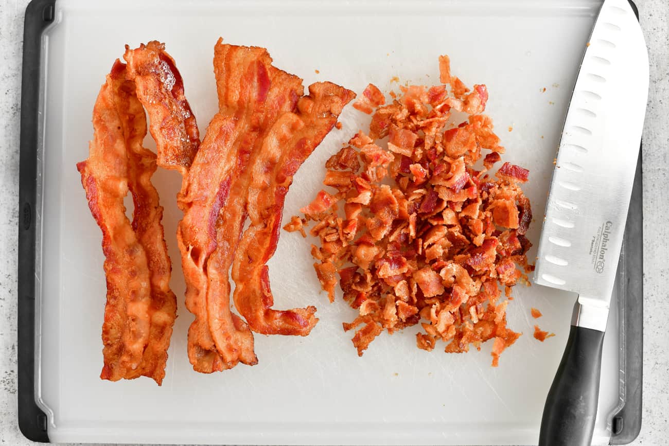 bacon slices and pieces on cutting board with knife