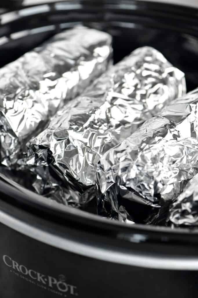foil wrapped breakfast burritos in a crockpot