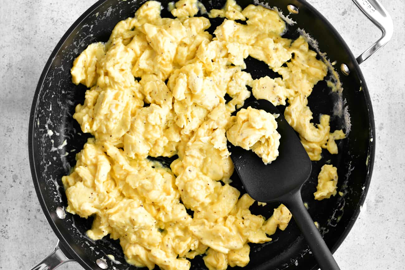 scrambled eggs in skillet with black spatula