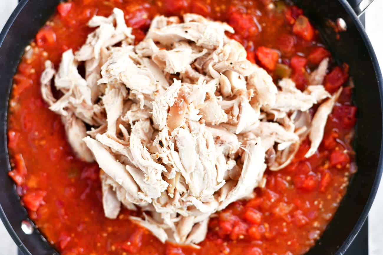 shredded chicken and red sauce in a frying pan