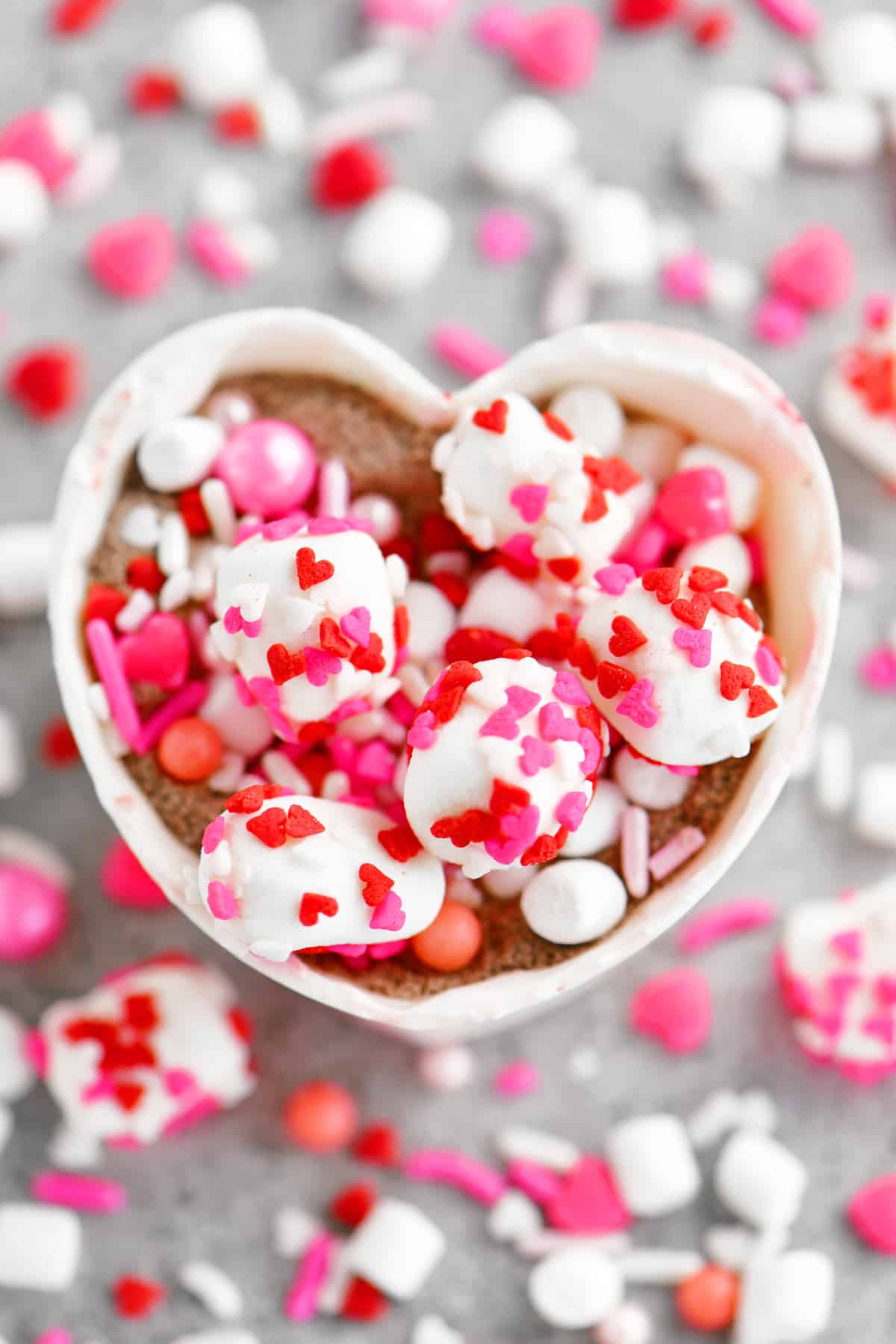 a topdown view of candy filling inside of heart shaped hot chocolate bomb