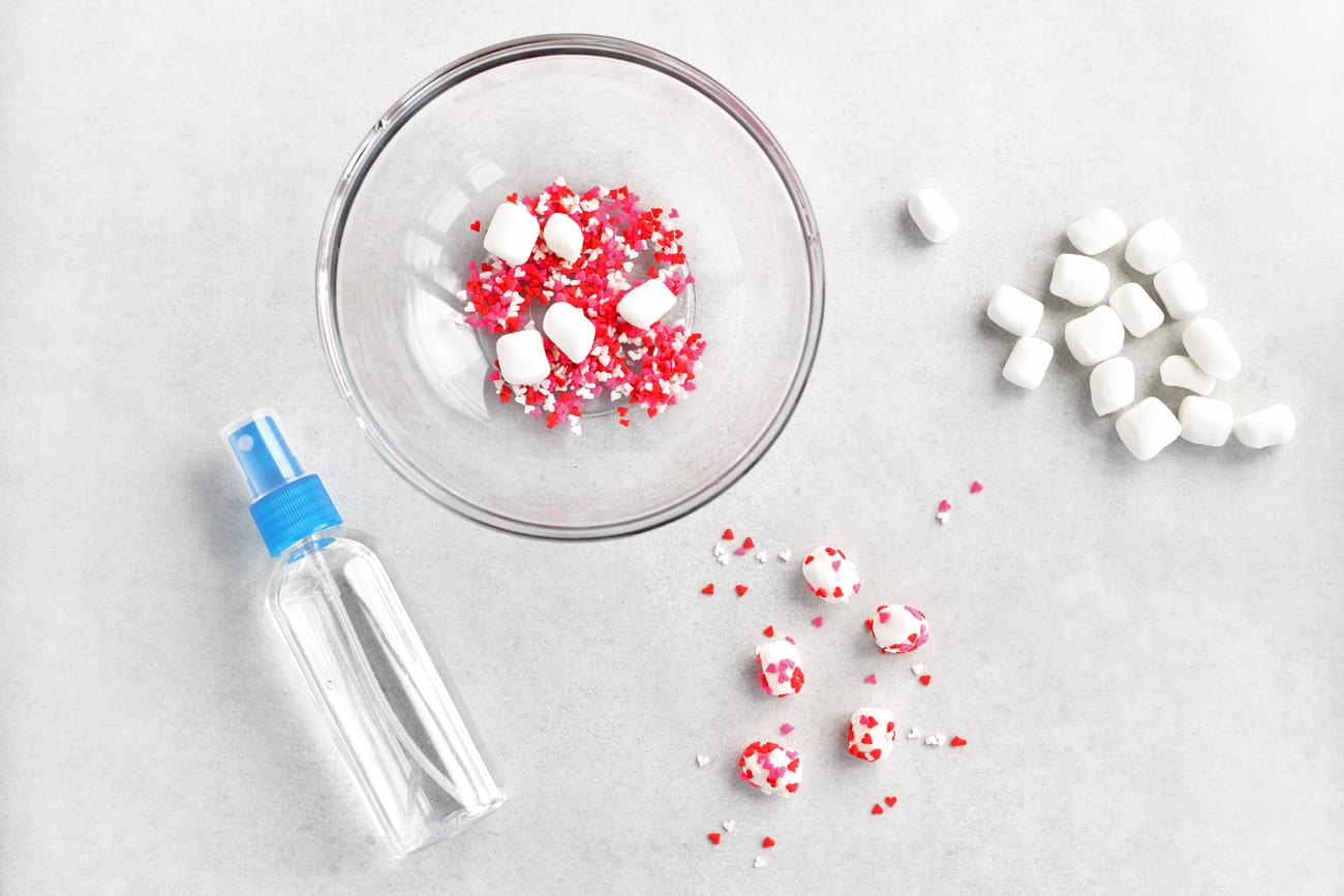 heart shaped sprinkles in a bowl, mini marshmallows and a spray bottle