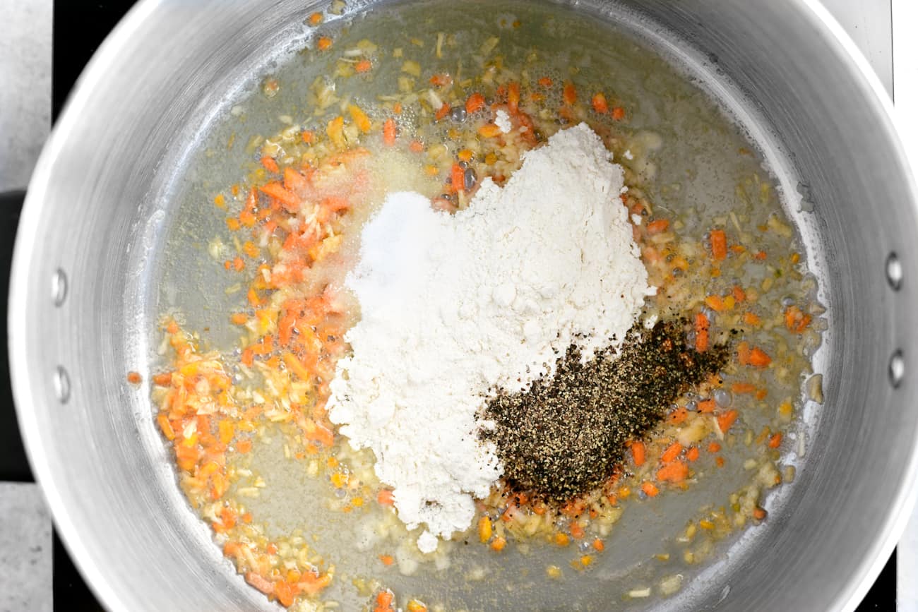 flour, pepper, onion and carrots in a large cooking pot