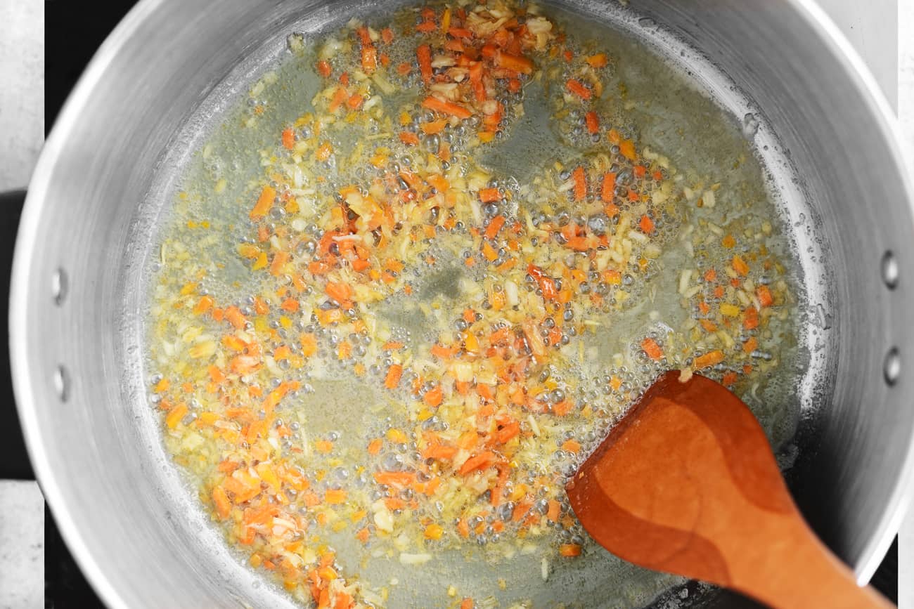 stirring the carrots and onions in the grease and butter