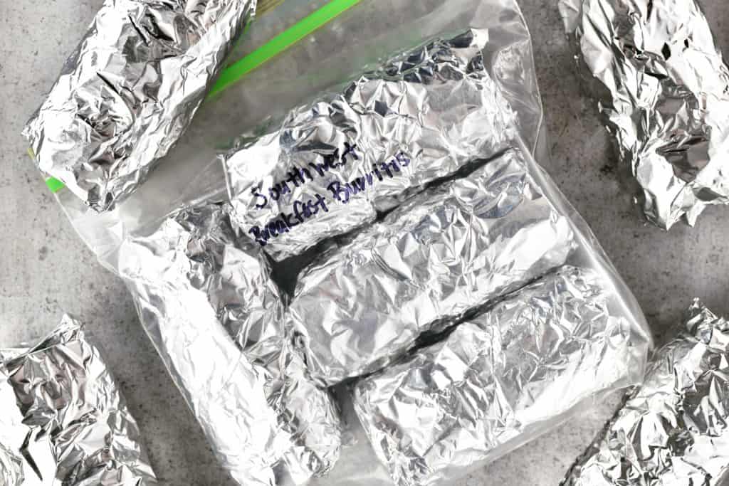 foil wrapped burritos in a sealable plastic bag, labeled for the freezer