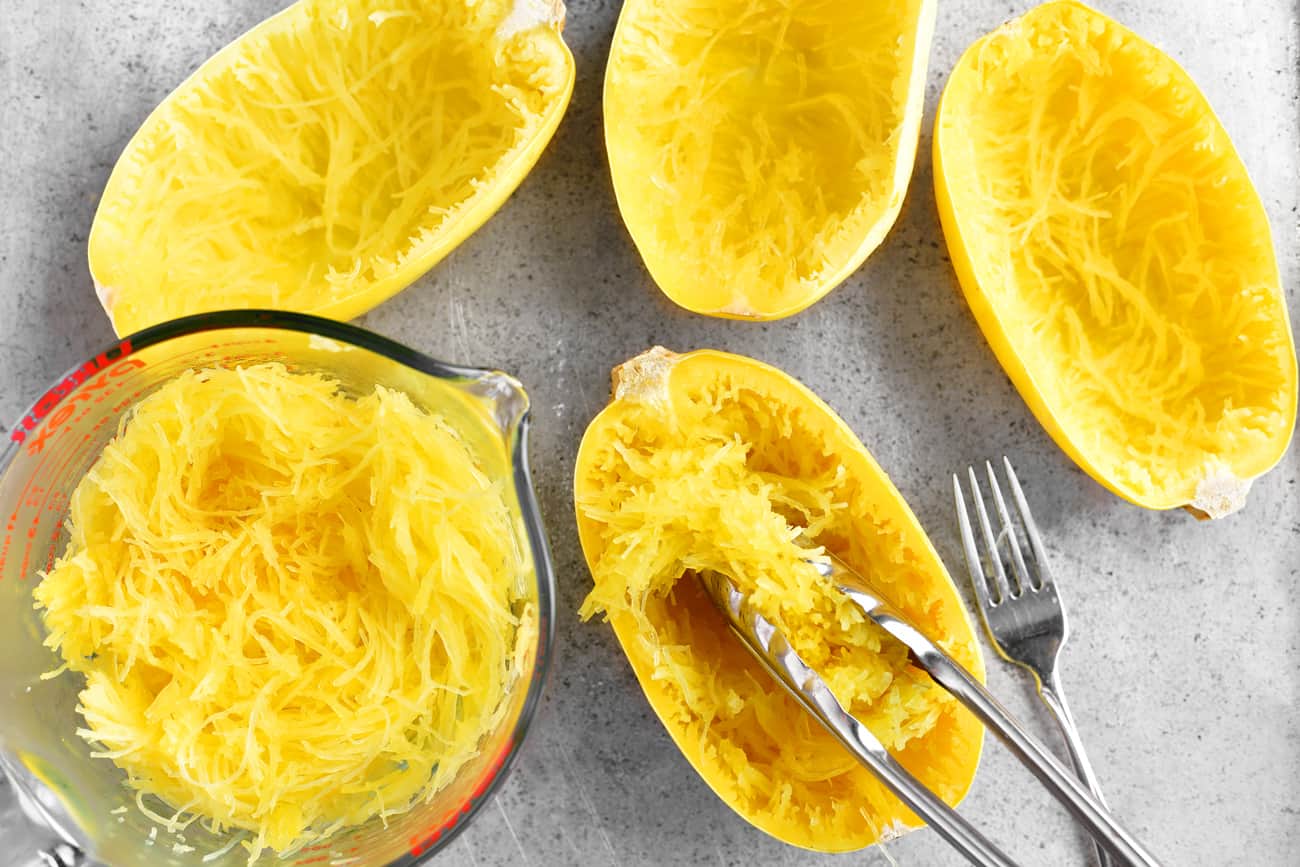 scooping the spaghetti squash into a mixing bowl