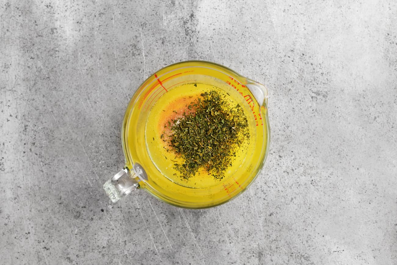 spices and melted butter in a glass measuring cup