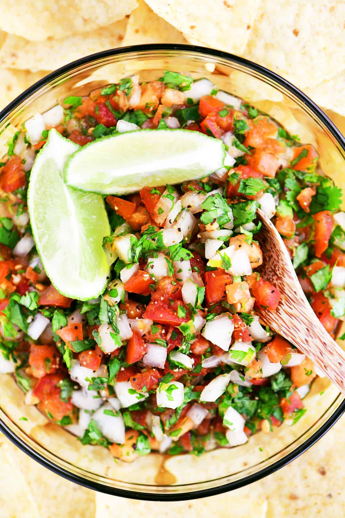 looking down on a colorful bowl of pico de gallo surrounded by tortilla chips