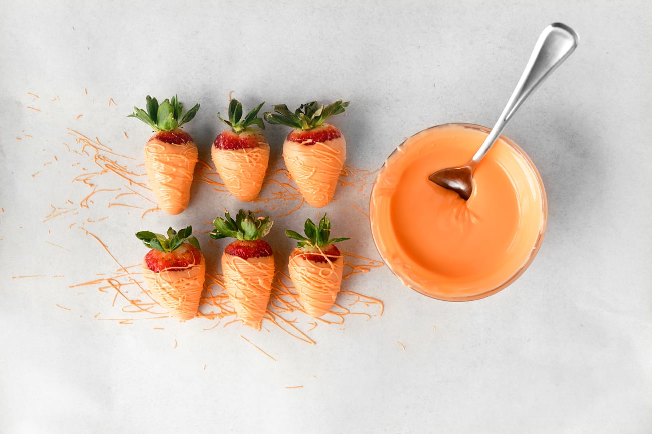 dipped strawberries and orange candy melted in a bowl