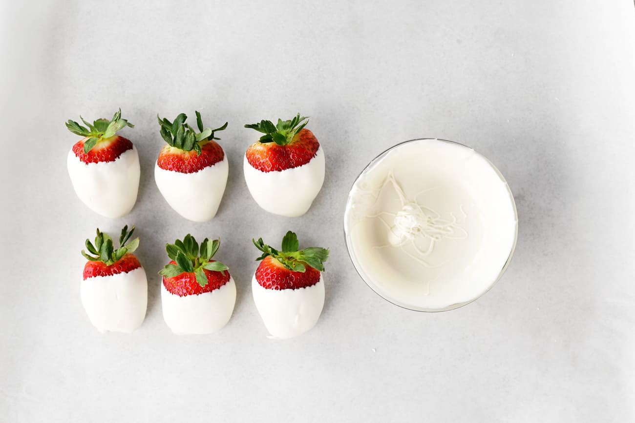 white candy melted in a bowl and dipped strawberries