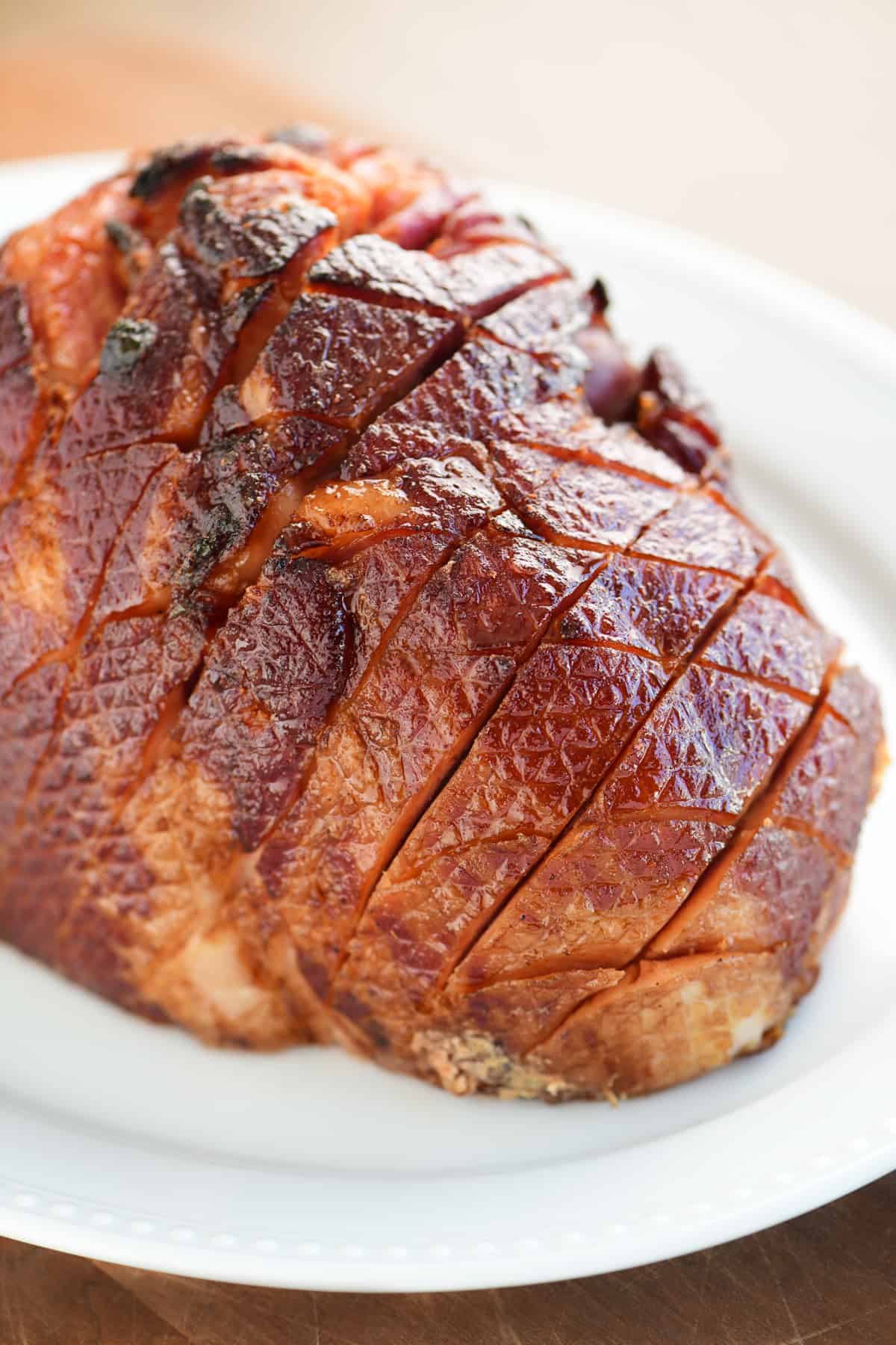 honey glazed ham on a white serving platter.