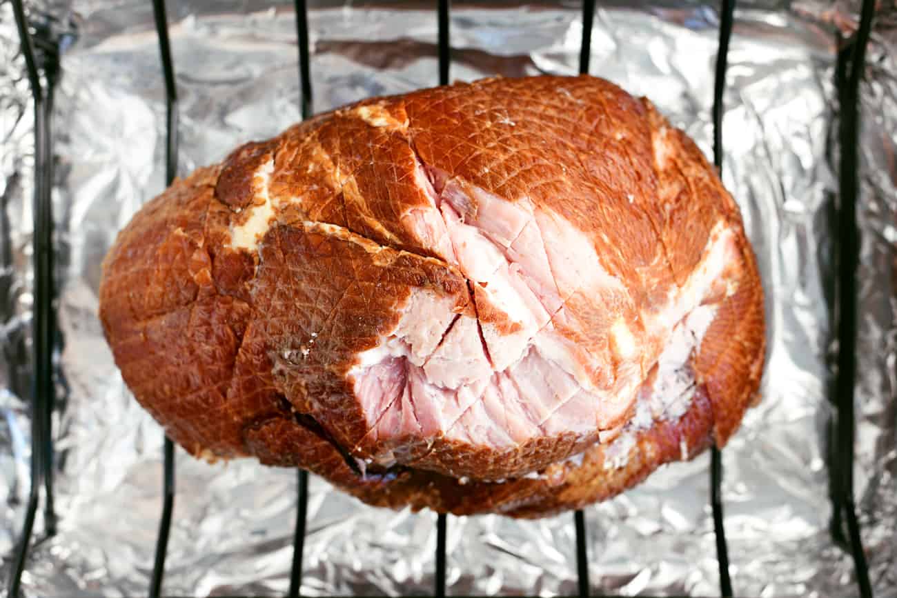 the scored ham in a roasting pan