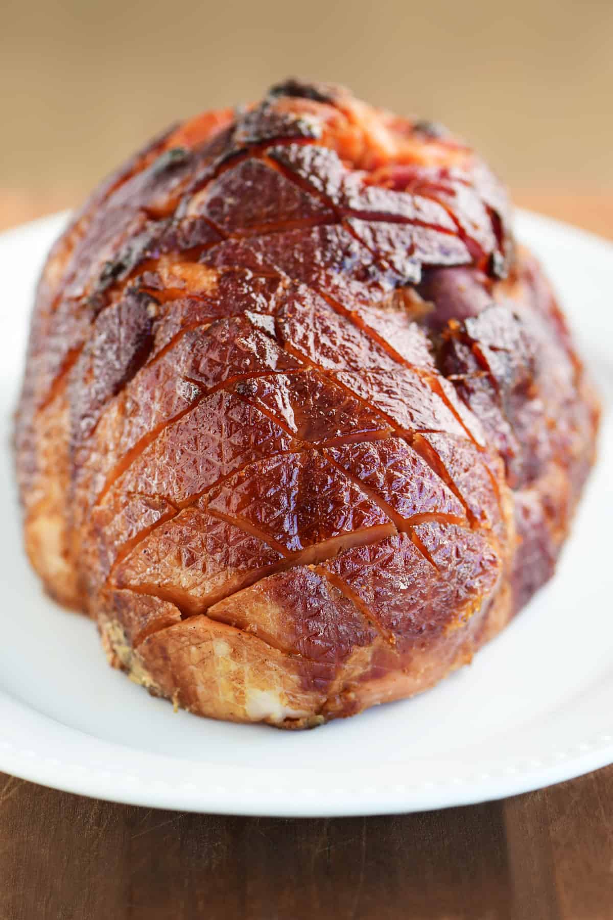 cooked glazed ham on a white serving platter