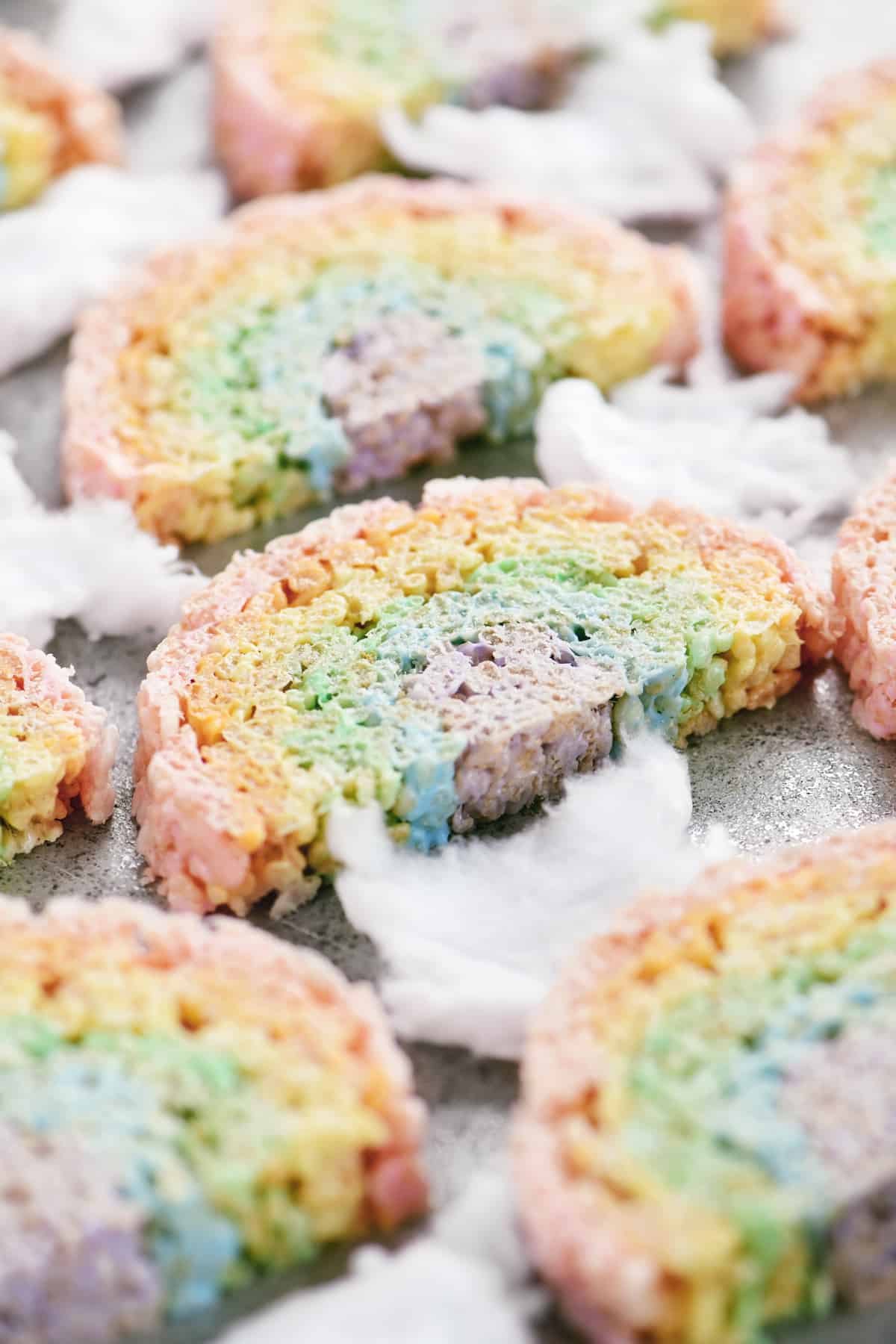 rainbow rice krispie treats and white fluffy cotton candy on a pan