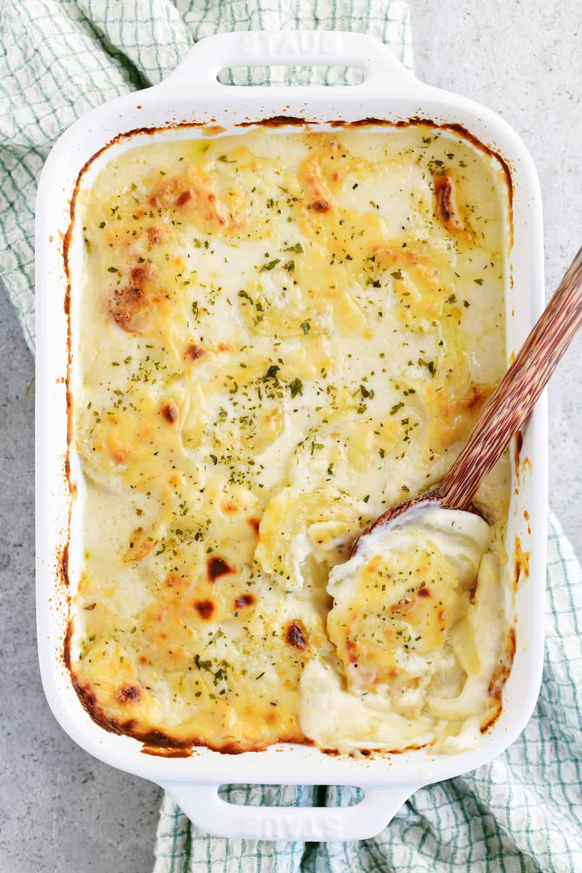 a spoon dipped into the cooked scalloped potatoes