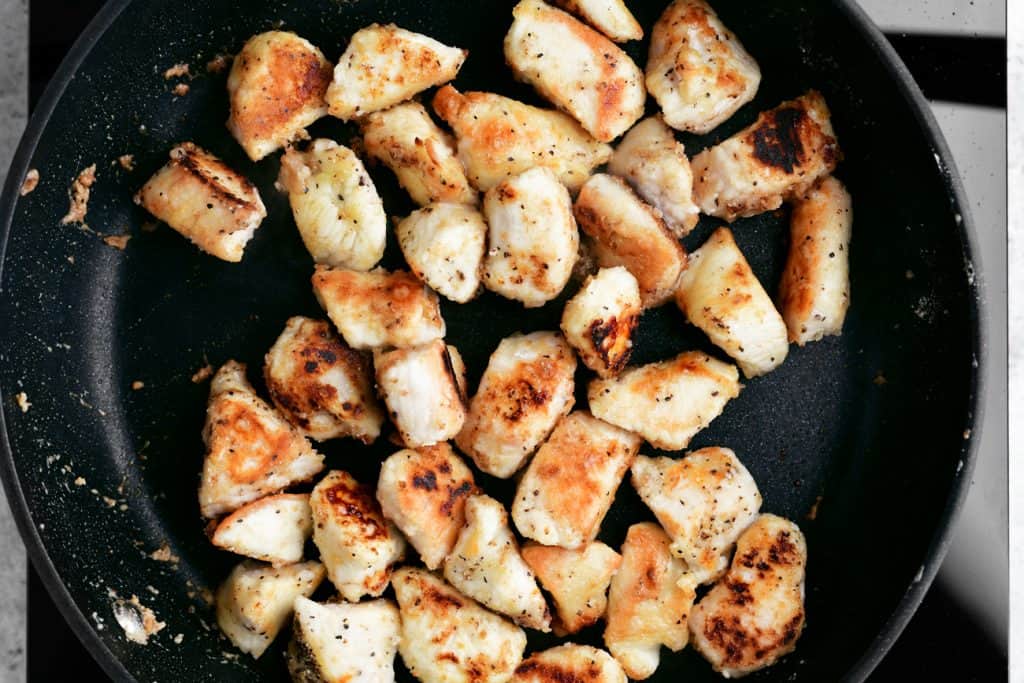 cubed chicken cooking in a skillet