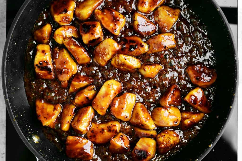 boiling sauce in pan with chicken cubes