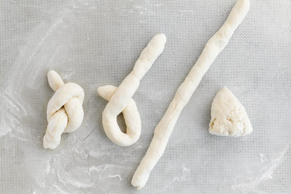 steps to forming a garlic knot with two ingredient dough