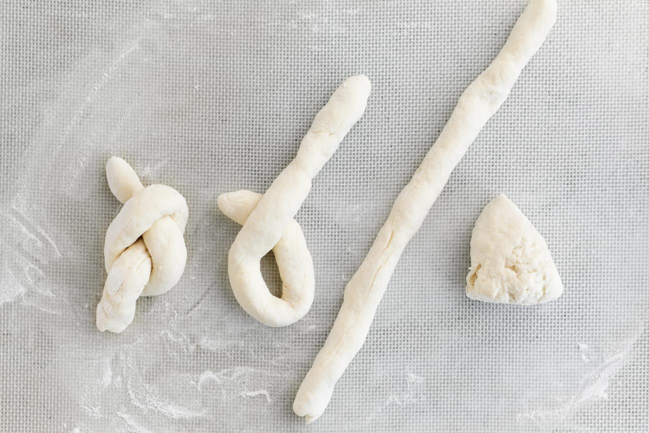 Steps to forming a garlic knot with two ingredient dough.