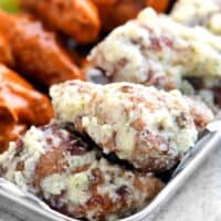 chicken wings with parmesan garlic sauce coating in a tray