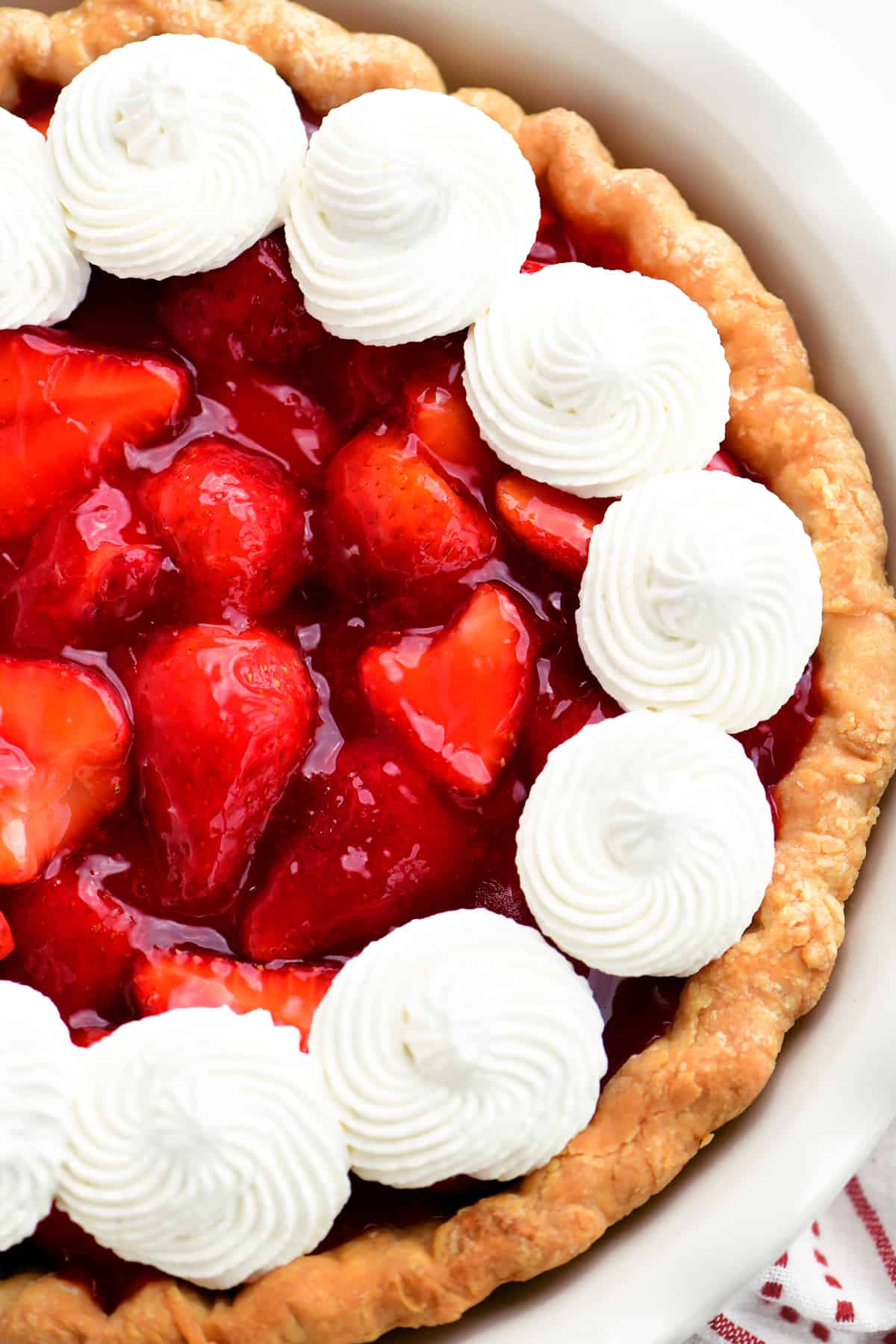 a strawberry pie with jello in a white dish