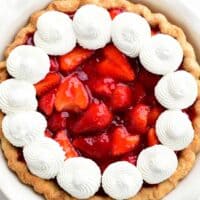 a strawberry pie with whipped cream dollops on top