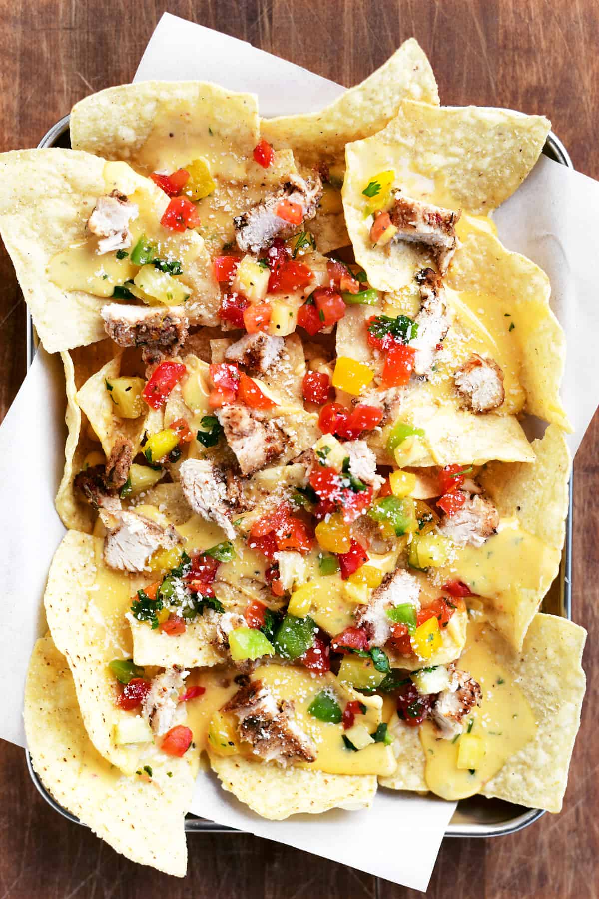 nachos with chicken, salsa, and cheese on top